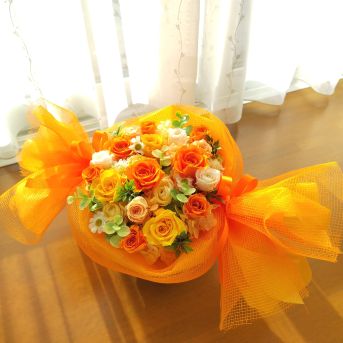 オレンジ系の花をキャンディーのようにラッピングしたプリザーブドフラワー