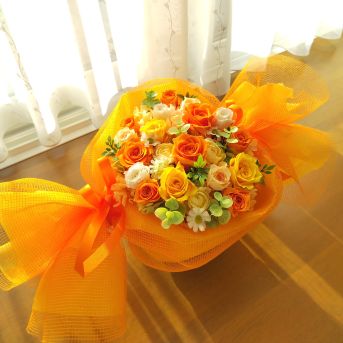 オレンジ系の花をキャンディーのようにラッピングしたプリザーブドフラワー