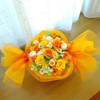 オレンジ系の花をキャンディーのようにラッピングしたプリザーブドフラワー