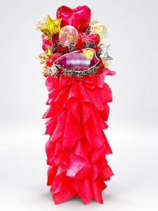 赤バラとかすみ草の生花にゴールドの造花の葉物を合わせた、赤を基調とするスタンド花